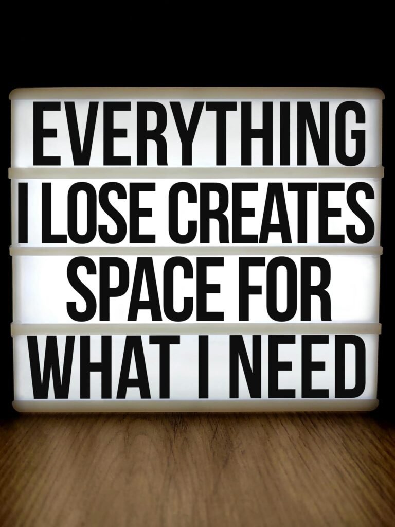 Motivational lightbox with quote: 'Everything I Lose Creates Space for What I Need'.