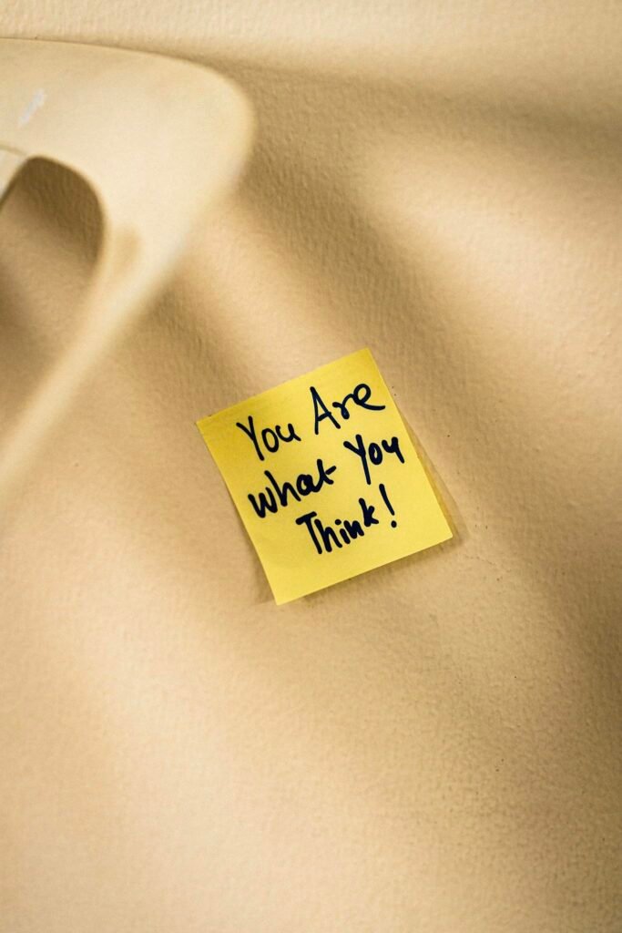 Yellow sticky note with motivational message on beige surface.